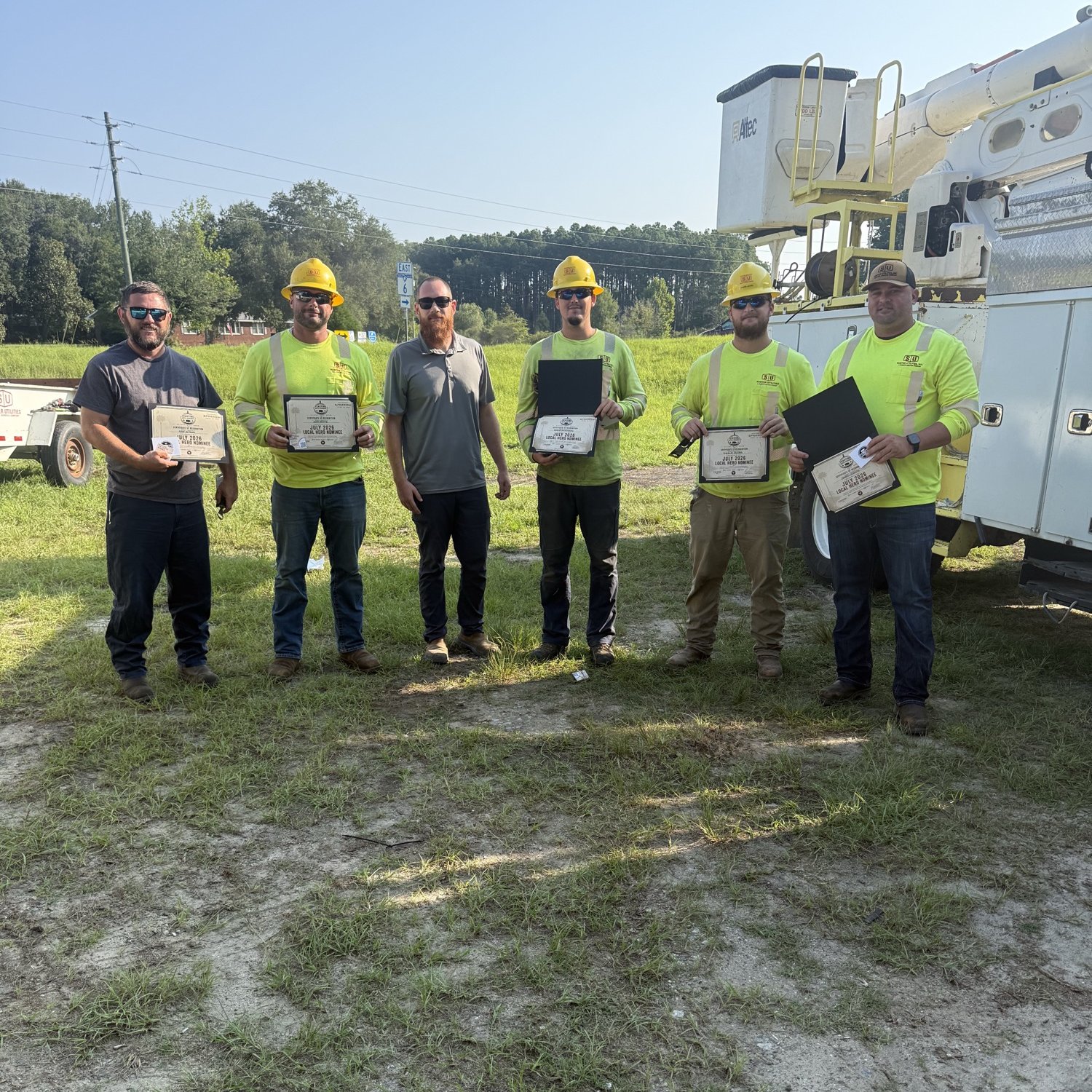 Feasting With Friends presenting a Local Hero Nominee certificate to a utility crew